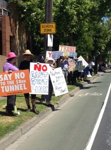 People holding protest posters beside the road